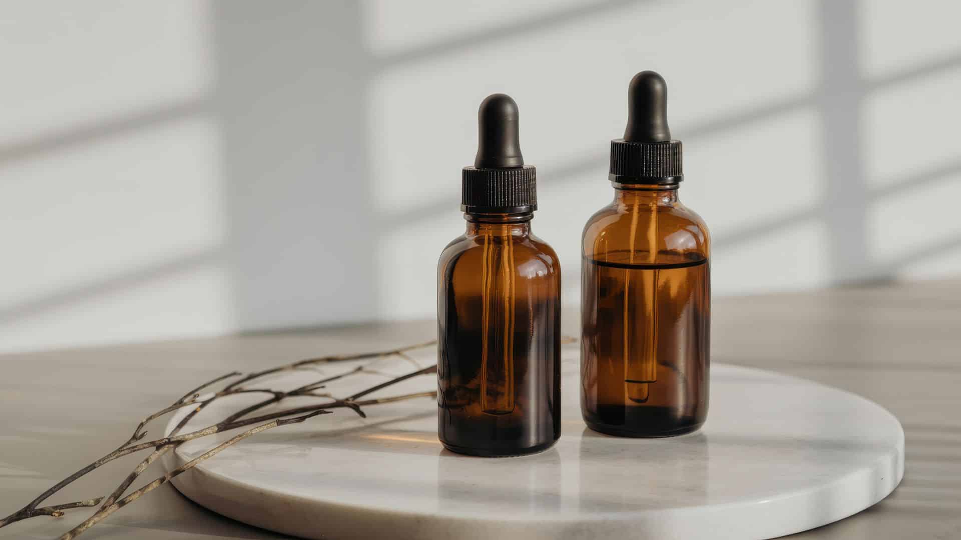 Two amber glass dropper bottles displayed side by side, often used to compare live sauce vs live resin concentrate forms.