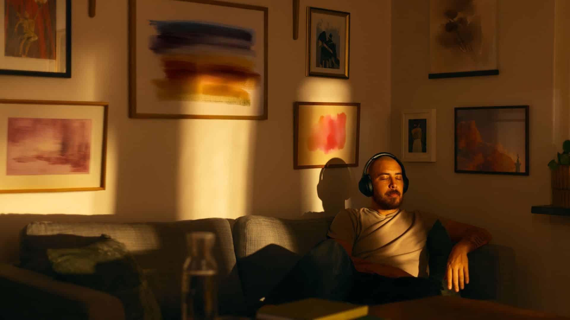 Person relaxing on a couch in warm sunlight, representing a calm comparison between live sauce vs live resin cannabis concentrates.